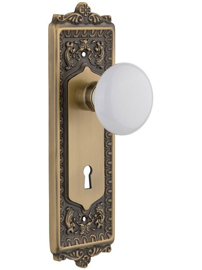 Egg and Dart Style Mortise Lock Set with White Porcelain Door Knobs in Antique Brass.
